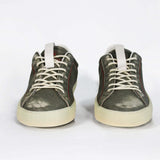 Front view of low top aged khaki sneaker with white accents. Perforated khaki leather upper with red stitching and pale rubber sole.