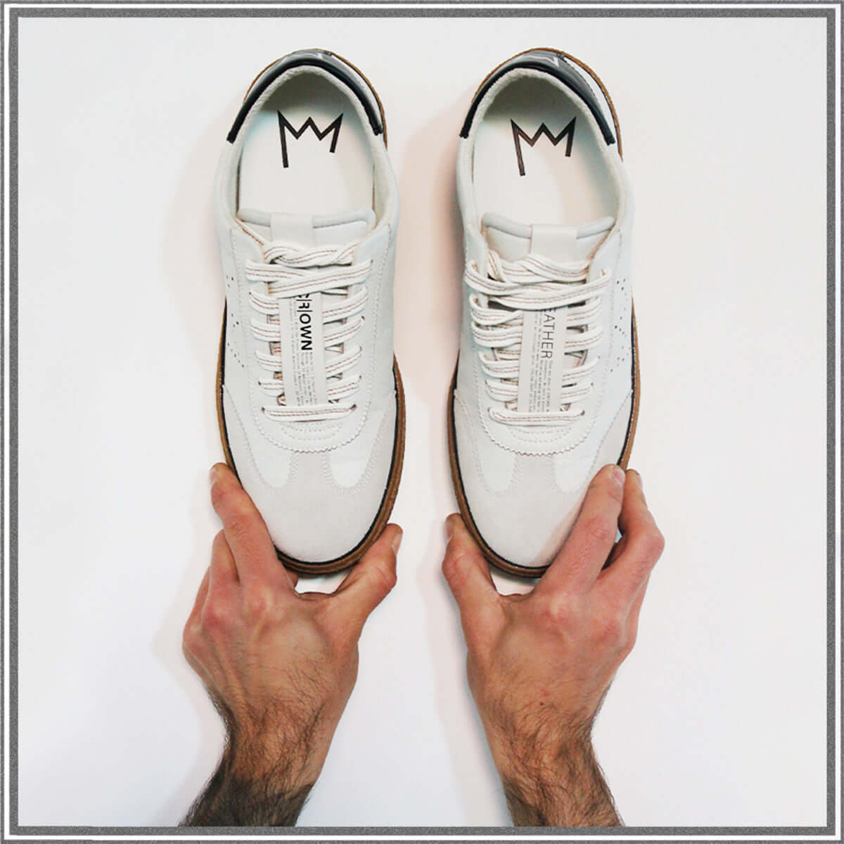 Model T low top sneaker style being held up.