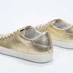 Women's Low-top PURE sneaker in Metallic Gold Leather shown from the back, displaying the Italian craftsmanship.